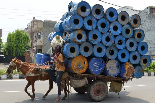 An Indian man transports empty container drums on a cart pulled by a horse in Amritsar on July 21, 2017. (Photo by Narinder Nanu/AFP Photo)