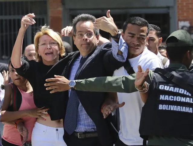Venezuelan General Prosecutor Luisa Ortega Diaz, left, is surrounded by loyal employees of the General Prosecutor's office, as she was barred from entering by security forces, outside of the General Prosecutor headquarters in Caracas, Venezuela, Saturday, August 5, 2017. Security forces surrounded the entrance ahead of a session of the newly-installed constitutional assembly in which the pro-government body is expected to debate the onetime loyalist turned arch critic's removal. (Photo by Wil Riera/AP Photo)
