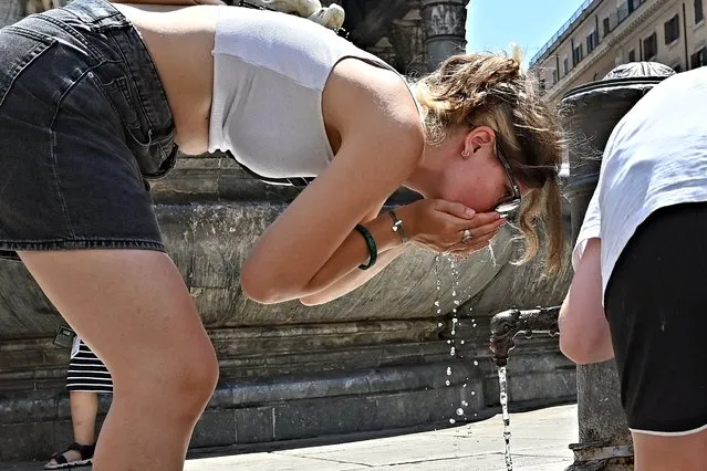 Tourists cool off and drink water from a fountain in front of the Pantheon in Rome, on July 19, 2022, amid a fierce heatwave which sweeps Europe. Europe's searing heatwave is generating very high levels of harmful ozone pollution, the region's atmospheric monitoring service warned, adding that large areas of western Europe also face “extreme” danger of wildfires. (Photo by Andreas Solaro/AFP Photo)