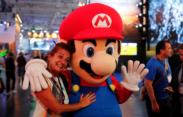 A woman poses with Nintendo's Mario at the world's largest computer games fair, Gamescom, in Cologne, Germany August 23, 2017. (Photo by Wolfgang Rattay/Reuters)