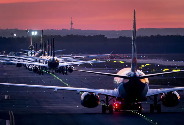 Aircrafts are parked on a runway at the airport in Frankfurt, Germany, Sunday, March 15, 2020. Due to the Coronavirus Lufthansa had to cancel half of its flights. For most people, the new coronavirus causes only mild or moderate symptoms. For some, it can cause more severe illness, especially in older adults and people with existing health problems. (Photo by Michael Probst/AP Photo)