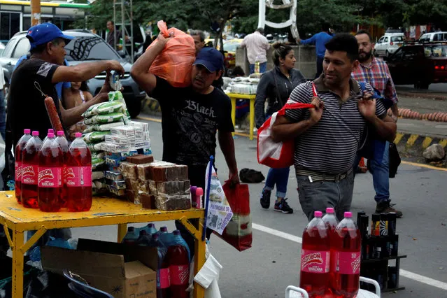 Colombian street vendor (L) sells his products at the Colombian-Venezuelan border in Cucuta, Colombia, July 16, 2016. (Photo by Carlos Eduardo Ramirez/Reuters)