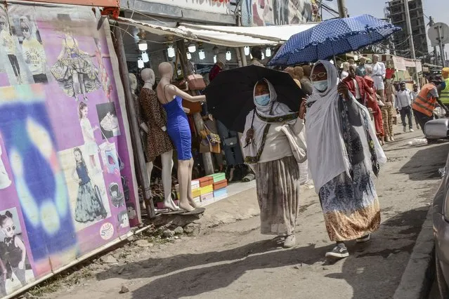 Pedestrians walk along a street in downtown Addis Ababa, Ethiopia on Tuesday, February 15, 2022. (Photo by AP Photo/Stringer)
