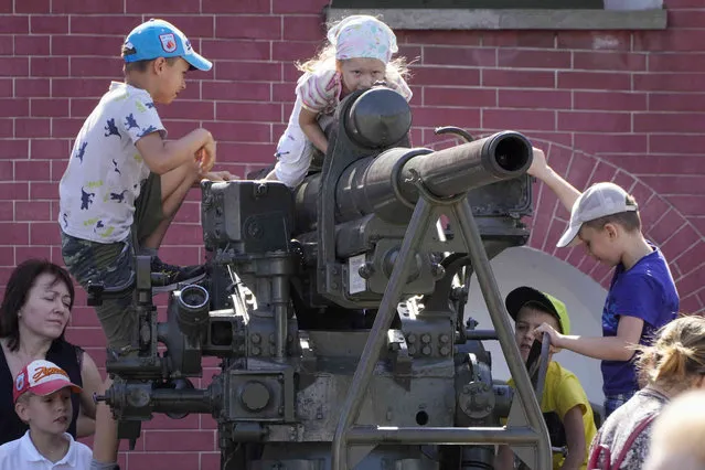 Children play on a Soviet anti-aircraft gun in the Saints Peter and Paul Fortress in St. Petersburg, Russia, Saturday, August 20, 2022. (Photo by Dmitri Lovetsky/AP Photo)