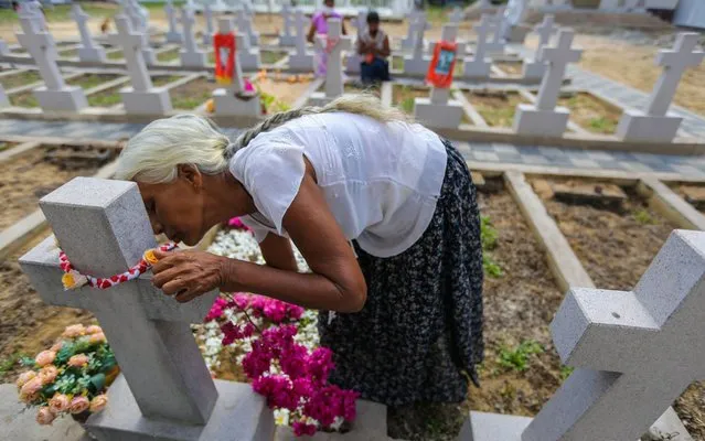 A woman lays flowers a the grave of an Easter Sunday 2019 suicide bomb attack victim, at the St. Sebastian's church, in Katuwapitiya, Sri Lanka, 21 April 2020. This year the 21 April marks the first anniversary of a terrorist attack that saw three churches and three luxury hotels targeted in Colombo, in series of coordinated suicide bombings. The bombings killed more than 250 people. (Photo by Chamila Karunarathne/EPA/EFE/Rex Features/Shutterstock)