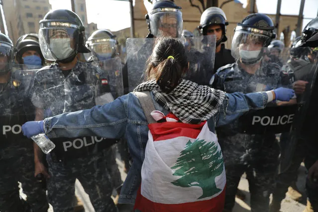 An anti-government protester confronts during a protest against the deepening financial crisis, in Beirut, Lebanon, Tuesday, April 28, 2020. Hundreds of protesters in Lebanon's northern city of Tripoli set fire Tuesday to two banks and hurled stones at soldiers, who responded with tear gas and batons in renewed clashes triggered by an economic crisis spiraling out of control amid a weeks-long virus lockdown. (Photo by Hussein Malla/AP Photo)
