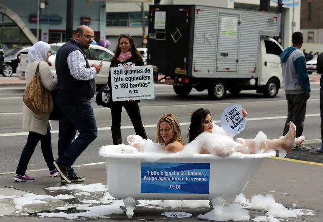 Naked women from the People for the Ethical Treatment of Animals (PETA) hold signs and take bath while promoting a vegan diet at Paulista avenue in Sao Paulo, Brazil, August 2, 2016. (Photo by Paulo Whitaker/Reuters)