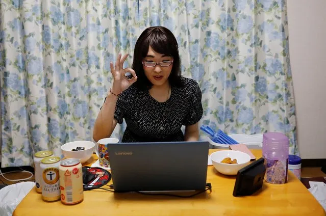 A male crossdresser, who goes by the pseudonym Anzu, gestures to other participants as he uses the online drinking party service “Tacnom” on a laptop at his house in Yokohama, Japan on May 2, 2020. (Photo by Kim Kyung-Hoon/Reuters)