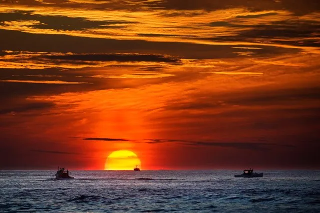 Lobster fishermen are already at work as the sun rises over the Atlantic Ocean, Thursday, September 8, 2022, off of Kennebunkport, Maine. (Photo by Robert F. Bukaty/AP Photo)