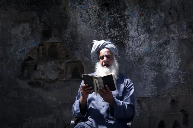 A Palestinian man reads the Koran during the holy month of Ramadan in Gaza City during the COVID-19 coronavirus pandemic on April 28, 2020. (Photo by Mohammed Abed/AFP Photo)