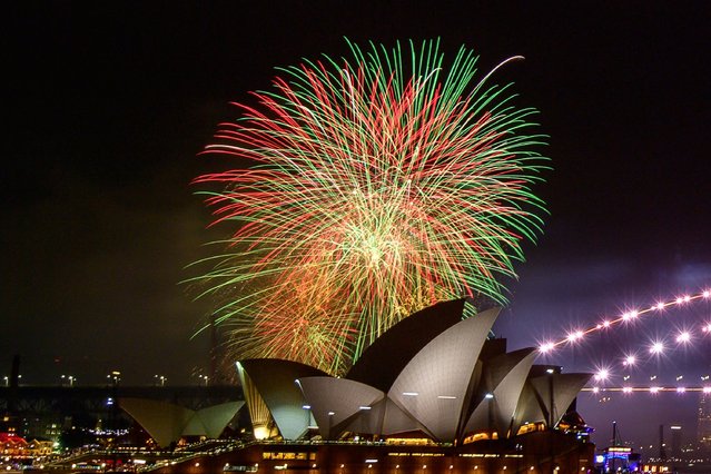 The 9pm “family fireworks” explode over Sydney Opera House during New Year's Eve celebrations in Sydney on December 31, 2023. (Photo by Izhar Khan/AFP Photo)