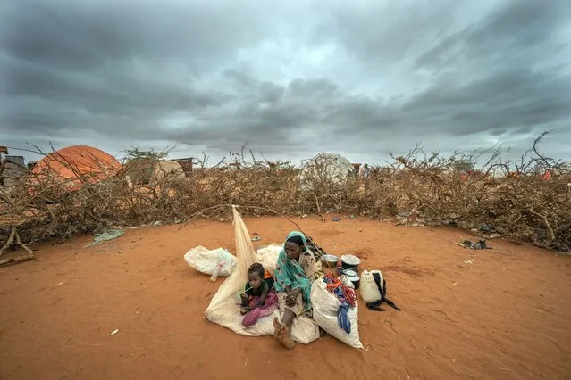 A Somali woman and child wait to be given a spot to settle at a camp for displaced people on the outskirts of Dollow, Somalia on Tuesday, September 20, 2022. (Photo by Jerome Delay/AP Photo)
