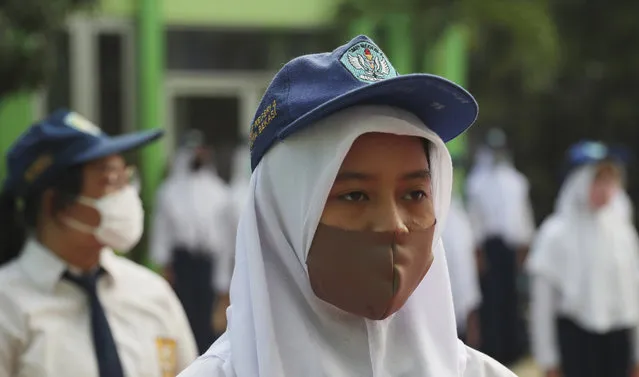 Students wear face maska as a precaution against the new coronavirus during the first day of reopening of state high schools in Bekasi on the outskirts of Jakarta, Indonesia, July 13, 2020. (Photo by Achmad Ibrahim/AP Photo)