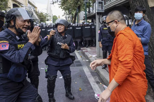 Police gesture in respect towards a monk as they block protesters trying to march to the Asia-Pacific Economic Cooperation APEC summit venue, Friday, November 18, 2022, in Bangkok, Thailand. (Photo by Wason Wanichakorn/AP Photo)