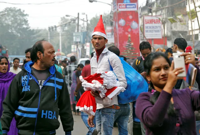 A vendor wearing a Santa Claus cap waits for customers in a street ahead of Christmas in Kolkata, India, December 19, 2017. (Photo by Rupak De Chowdhuri/Reuters)