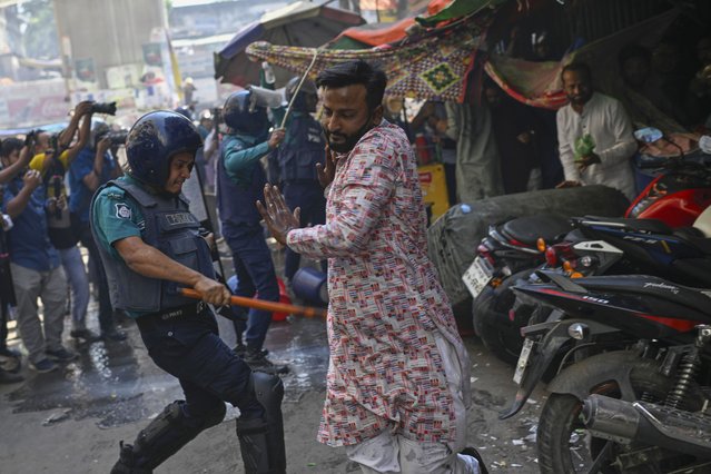 Policemen use batons to disperse supporters of the banned Islamist group Hizbut Tahrir near Baitul Mokarram Mosque in Dhaka, Bangladesh, Friday, March 7, 2025. (Photo by Mahmud Hossain Opu/AP Photo)