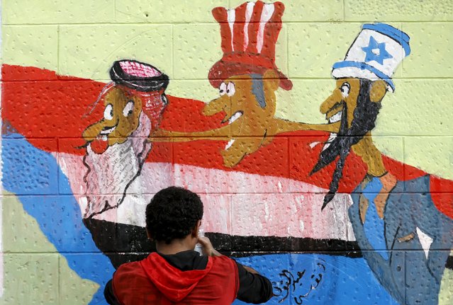 A pro-Houthi activist works on graffiti during a campaign against Saudi-led air strikes on the wall of the Saudi embassy in Sanaa August 2, 2015. (Photo by Khaled Abdullah/Reuters