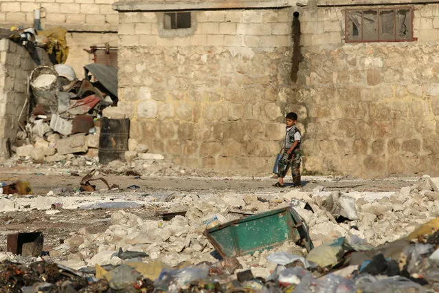 A boy walks past garbage and debris in the rebel-held al-Sheikh Said neighbourhood of Aleppo, Syria September 1, 2016. (Photo by Abdalrhman Ismail/Reuters)