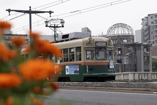 A running tram is seen near the Atomic Bomb Dome in Hiroshima, western Japan, Monday, August 3, 2020. A tram which survived the Hiroshima atomic bombing will run, without any passenger, on the streets on Aug. 6 to commemorate the day of atomic bombing in the city. (Photo by Eugene Hoshiko/AP Photo)