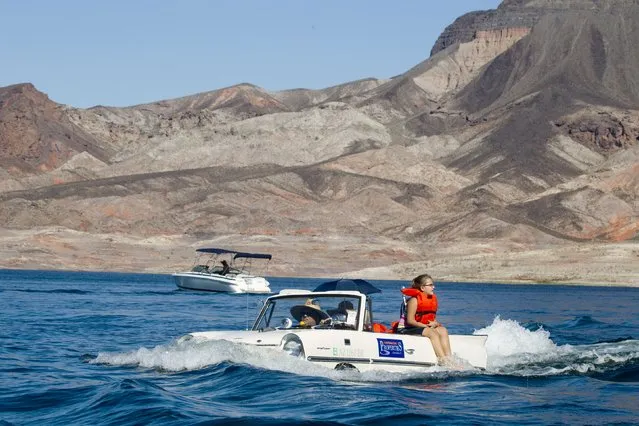 Hannah Baker, 9, of Lake Havasu, Arizona dangles her feet on the side of the family's 1965 Amphicar during the first Las Vegas Amphicar Swim-in at Lake Mead near Las Vegas, Nevada October 9, 2015. (Photo by Steve Marcus/Reuters)