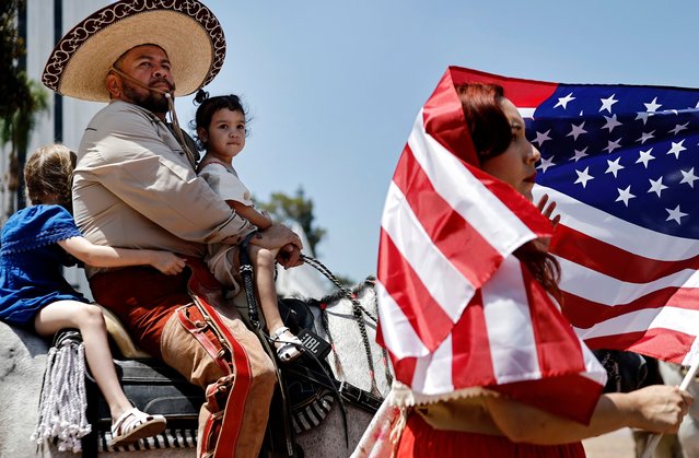 Enrique Vega sits on his horse with daughters Valentina and Carolina as his wife Juliana holds an American flag at the “Human Rights Unity Ride”, protesting controversial ongoing federal immigration raids in Los Angeles County, on June 22, 2025 in Compton, California. The ride from Paramount to Compton called for solidarity with the immigrant community as ICE raids have sparked widespread protests and compelled the Trump administration to activate members of the California National Guard and bring in U.S. Marines against the wishes of state and local leaders. (Photo by Mario Tama/Getty Images)