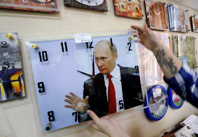 A vendor takes a wall clock, showing an image of Russian President Vladimir Putin, at a home improvement store in Krasnoyarsk, Russia September 22, 2016. (Photo by Ilya Naymushin/Reuters)