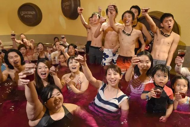 Bathers raise their glasses, containing 2014 vintage Beaujolais Nouveau wine, at a “wine spa” in Hakone town, Kanagawa prefecture, some 100-kilometres west of Tokyo on November 20, 2014, after an embargo on the wine was removed. (Photo by Toru Yamanaka/AFP Photo)