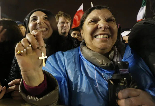 Crowds cheer after white smoke billowed from the chimney on the Sistine Chapel indicating that a new pope has been elected in St. Peter's Square at the Vatican, Wednesday, March 13, 2013. (Photo by Dmitry Lovetsky/AP Photo)