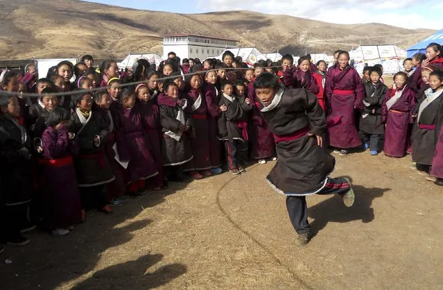 Tibetan students from a local primary school skip rope as they exercise near their temporary tents after an earthquake hit Kangding county, Sichuan province November 23, 2014. At least four people were killed and 54 others injured on Saturday after a 6.3 magnitude quake hit Kangding County in southwest China's Sichuan Province, Xinhua News Agency reported. (Photo by Reuters/China Daily)