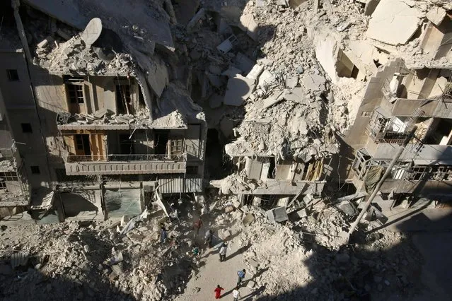 People dig in the rubble in an ongoing search for survivors at a site hit previously by an airstrike in the rebel-held Tariq al-Bab neighborhood of Aleppo, Syria, September 26, 2016. (Photo by Abdalrhman Ismail/Reuters)