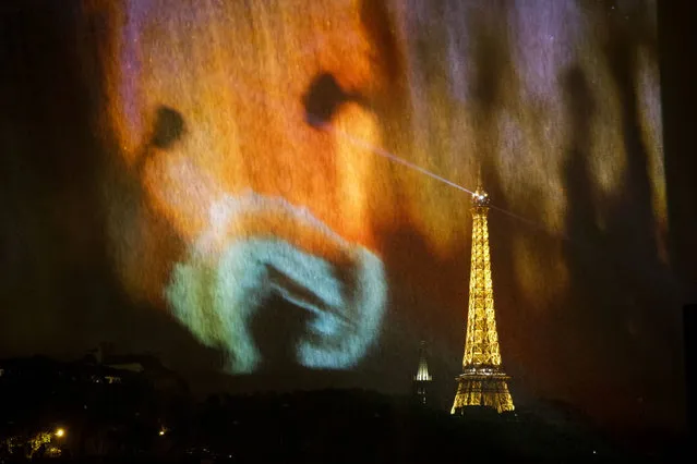 The Eiffel tower is seen through a screening by “Les ateliers du bout de la craie” next to the Seine in Paris on September 30, 2016 as part of the “Nuit Blanche” night-time arts festival. The 15th edition of the “Nuit Blanche”, which is centered on cultural events around the Seine and its bridges, takes place from October 1 to October 2, 2016. (Photo by Geoffroy van der Hasselt/AFP Photo)