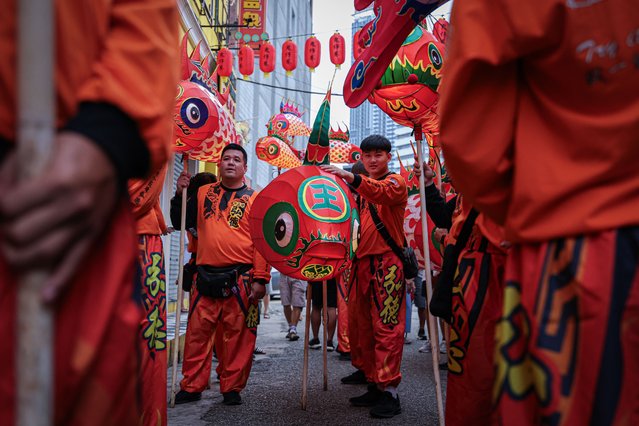 Troupes standing by with fish lanterns ahead of a fish parade at Kwai Chai Hong, a heritage revival back alley in Chinatown on January 11, 2025 in Kuala Lumpur, Malaysia. Kwai Chai Hong has created an immersive art installation in conjunction with the Lunar New Year, inspired by the idiom “Nian Nian You Yu”, meaning “Wishing Abundance Year After Year”. The installation transforms traditional fish lanterns into modern portable lights, blending cultural heritage with contemporary artistry. Visitors are invited to embark on a cultural journey celebrating generosity and prosperity, culminating in a vibrant fish parade through Chinatown led by the Malaysian Chinese community. (Photo by Annice Lyn/Getty Images)