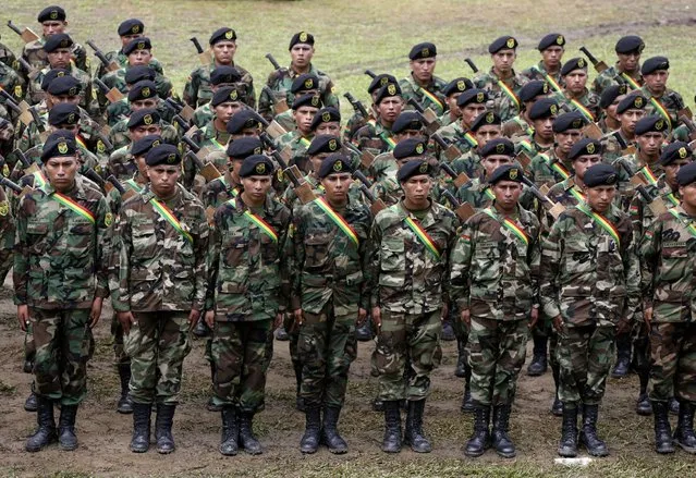 Soldiers, who were tasked to eradicate coca leaves in the fight against drugs, attend the end of their ceremony of the task in Chimore, east of La Paz, December 10, 2014. (Photo by David Mercado/Reuters)