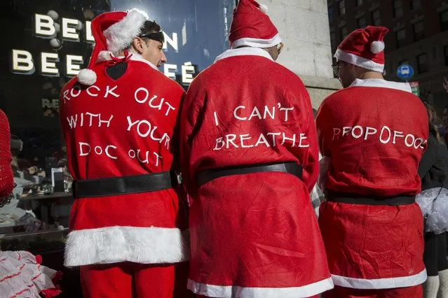 Men wear messages on their costumes as they take part in SantaCon in Midtown Manhattan, New York  December 13, 2014. (Photo by Elizabeth Shafiroff/Reuters)