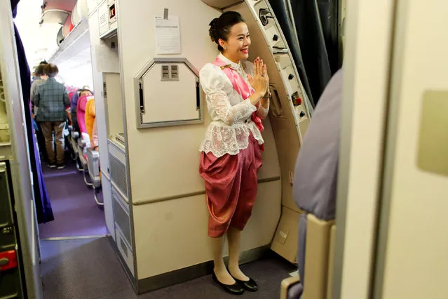 A Thai Airways flight attendant dressed in traditional costume welcomes passengers onboard, as interest for historical clothing rises within the country, in Chiang Mai, Thailand April 6, 2018. (Photo by Jorge Silva/Reuters)