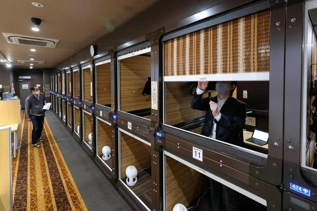 This picture taken on November 27, 2020 shows a floor of the capsule hotel Anshin Oyado Shinjuku, Tokyo, which has been renovated into a coworking space without the upper and lower partitions of the capsule. Facing unprecendented challenges due to the Covid-19 coronavirus pandemic, the capsule hotel renovated an entire floor to be used as a coworking space - offering office necessities such as high speed internet required for telework and web conferencing, including computer hardware and other computing devices. (Photo by Kazuhiro Nogi/AFP Photo)