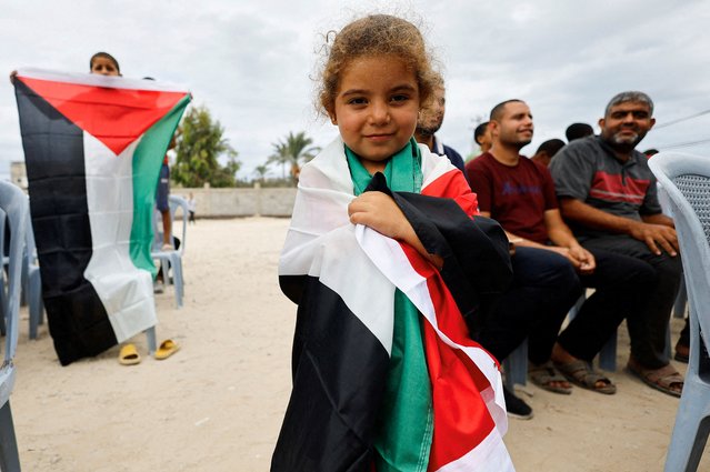 A girl holds a Palestinian flag, after U.S. President Donald Trump announced that Israel and Hamas agreed on the first phase of a Gaza ceasefire, in the central Gaza Strip on October 9, 2025. (Photo by Mahmoud Issa/Reuters)