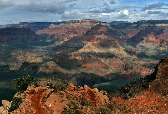 In this February 22, 2005, file photo, with the North Rim in the background, tourists hike along the South Rim of the Grand Canyon in Grand Canyon, Ariz. Crews are drilling at the bottom of the Grand Canyon to test the idea of shifting the area where water is drawn to serve millions of people at the park’s popular South Rim. The national park’s water supply comes from a natural spring that flows through 12.5 miles of pipeline. But the 1960s aluminum pipeline to the South Rim twists and turns around trails and through rocky terrain, frequently breaking and leaking. (Photo by Rick Hossman/AP Photo)