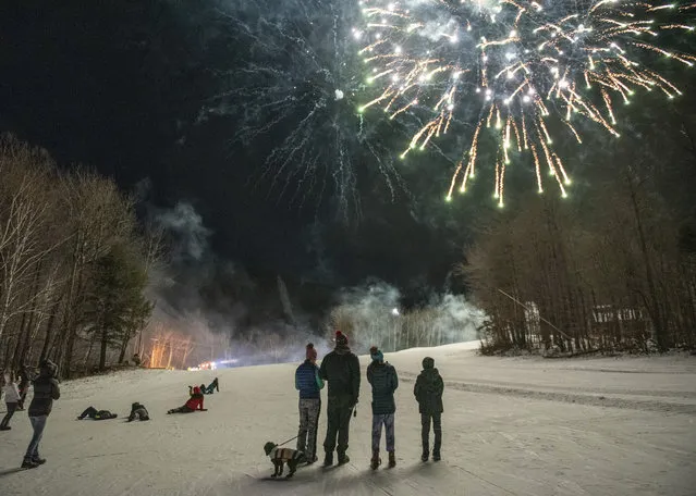 Sunday River guests watch the fireworks display on the side of the ski trails to ring in the New Year, Thursday, December 31, 2020 in Newry, Maine. All festivities stopped promptly at 9 PM in accordance with state guidelines. (Photo by Andree Kehn/Sun Journal via AP Photo)