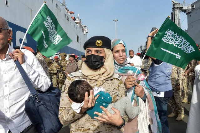 A Saudi Navy sailor carries a child as evacuees arrive at King Faisal Navy Base in Jeddah on April 26, 2023, following a rescue operation from Sudan. A ship carrying 1,687 civilians from more than 50 countries fleeing violence in Sudan docked in Saudi Arabia on April 26, the foreign ministry said, the largest evacuation effort by the Gulf kingdom so far. (Photo by Amer Hilabi/AFP Photo)
