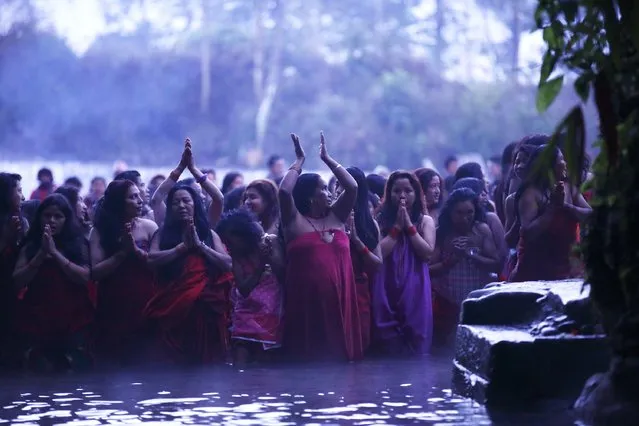 Devotees offer prayers as they submerge themselves in the river before taking a holy bath at Saali River during the first day of the Swasthani Brata Katha festival at Sankhu in Kathmandu January 5, 2015. (Photo by Navesh Chitrakar/Reuters)