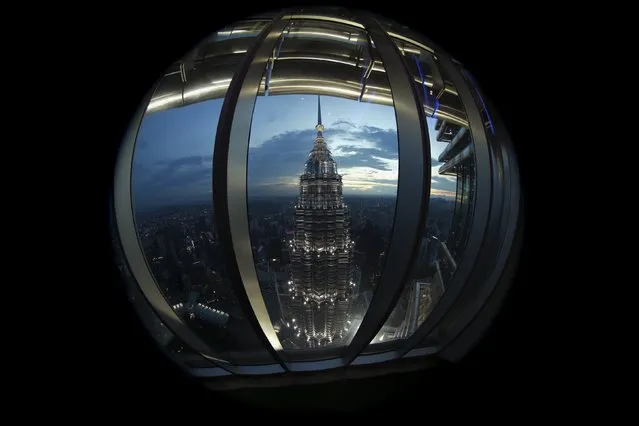 A view of one of the Petronas Towers is seen from windows of its twin building during the Association of Southeast Asian Nations (ASEAN) summit in Kuala Lumpur, Malaysia, November 22, 2015. Picture taken with a fisheye lens. (Photo by Jorge Silva/Reuters)