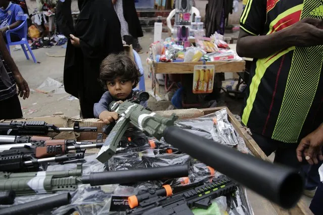 A child plays with a toy gun at a street market in Mogadishu, Somalia, Wednesday, April 19, 2023, as preparations are made for the Muslim holiday of Eid al-Fitr, next Friday, which marks the end of the holy fasting month of Ramadan. (Photo by Farah Abdi Warsameh/AP Photo)
