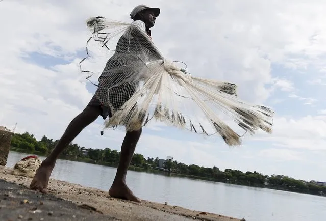A fisherman throws his net to catch fish in a lagoon in Batticaloa November 24, 2015. (Photo by Dinuka Liyanawatte/Reuters)
