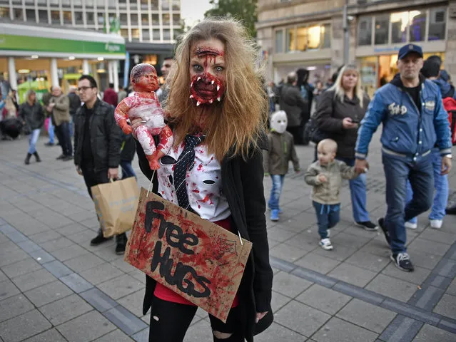 A woman dressed in a Halloween costume poses for a photo before participating in the zombie walk in Essen, Germany, Monday, October 31, 2016. Hundreds of young people celebrate Halloween at Germany's biggest horror walk through the city center of Essen. (Photo by Martin Meissner/AP Photo)