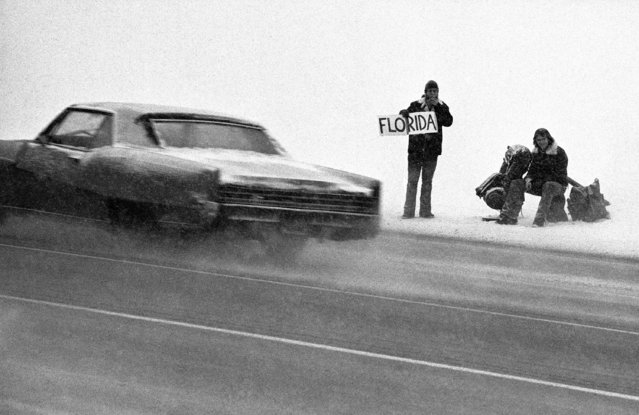 Two young men stand in a driving snow storm on Interstate 75 on Detroit's North Side, February 15, 1975, seeking a ride south to the sun. Southern and lower Michigan is expected to receive about 2 to 4 inches of the soft white powder. (Photo by AP Photo/JCH)
