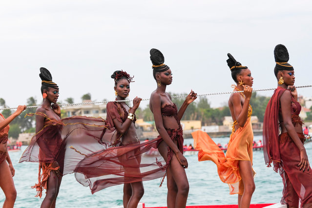 Models present creations in a traditional fishing boat during Dakar Fashion Week in Dakar, Senegal, Saturday, December 6, 2025. (Photo by Misper Apawu/AP Photo)
