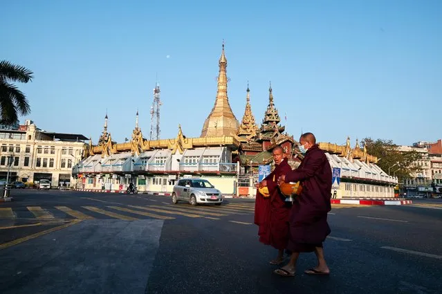 Buddhist monks walk past Sule pagoda in Yangon, Myanmar, February 1, 2021. (Photo by Reuters/Stringer)
