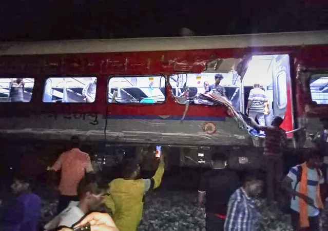 People inspect the site of passenger trains that derailed in Balasore district, in the eastern Indian state of Orissa, Friday, June 2, 2023. Two passenger trains derailed in India, killing at least 13 people and trapping hundreds of others inside more than a dozen damaged coaches, officials said. About 400 people were injured and taken to hospitals, and the cause of the accident was under investigation, officials said. (Photo by Press Trust of India via AP Photo)