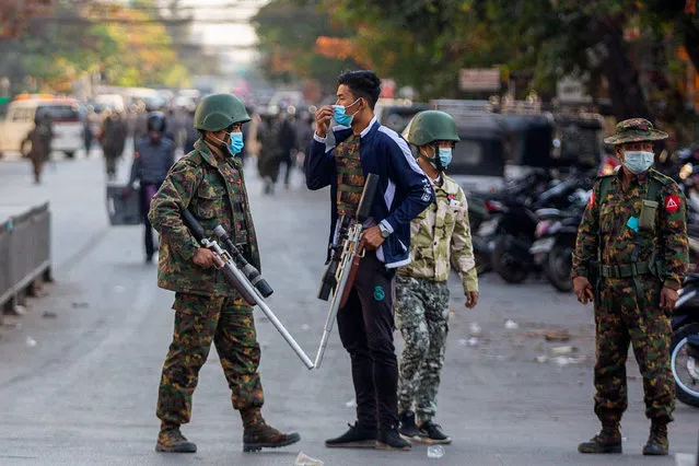 Soldiers carry guns during a clash with protesters demonstrating against the military coup in Mandalay on February 15, 2021. (Photo by AFP Photo/Stringer)